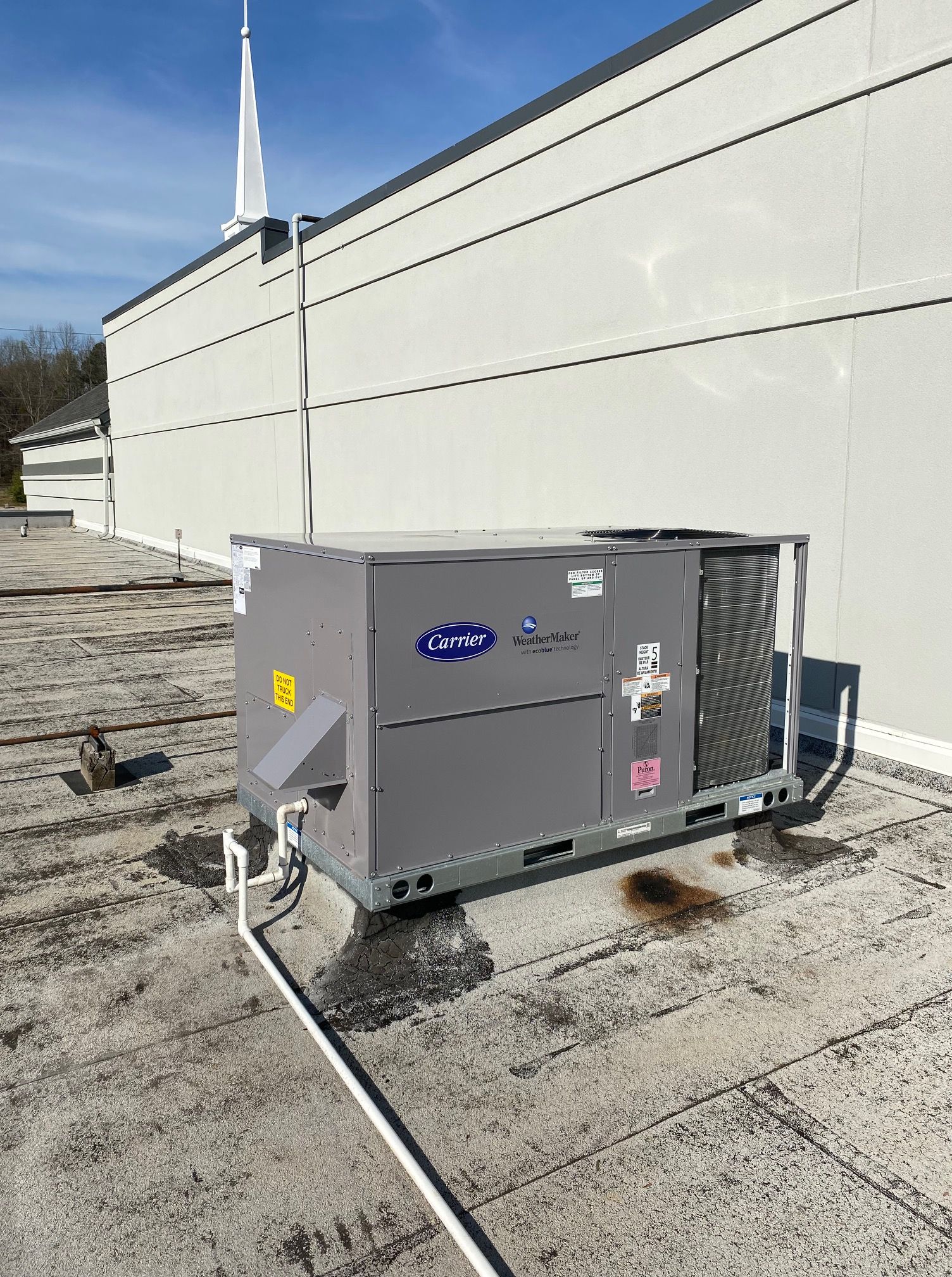 A large air conditioner is sitting on the roof of a building.