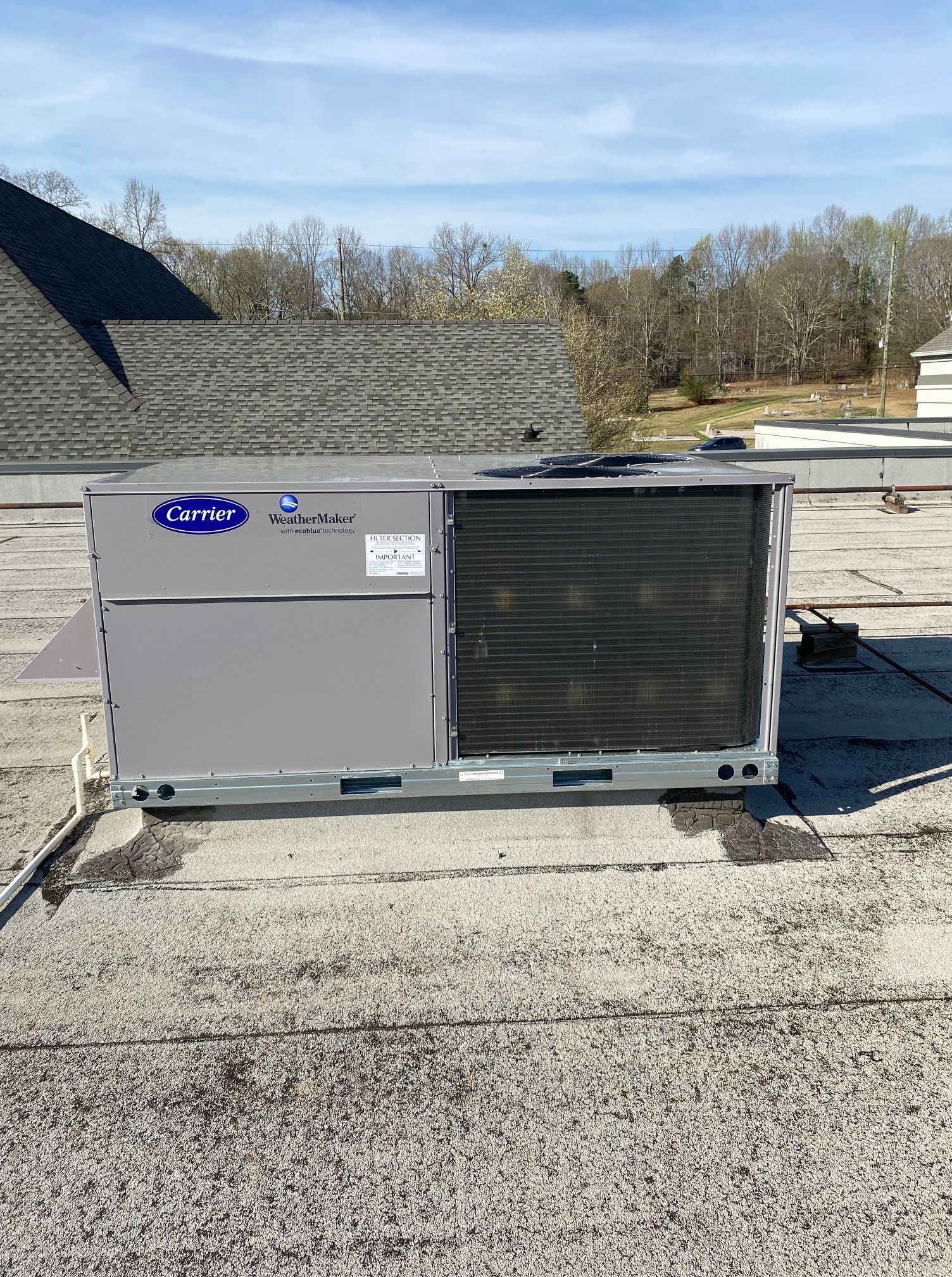 A carrier air conditioner is sitting on top of a roof.
