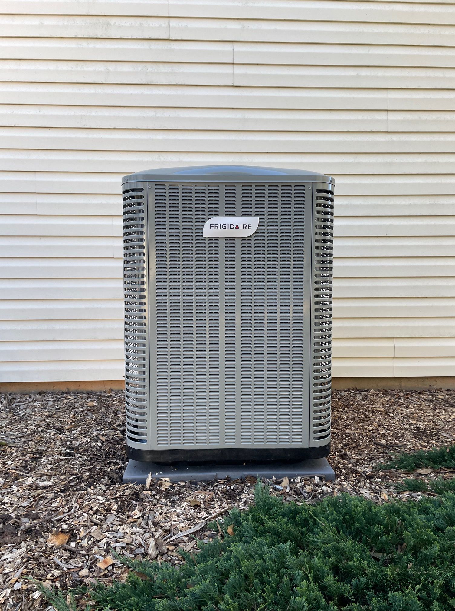 An air conditioner is sitting on the side of a house.