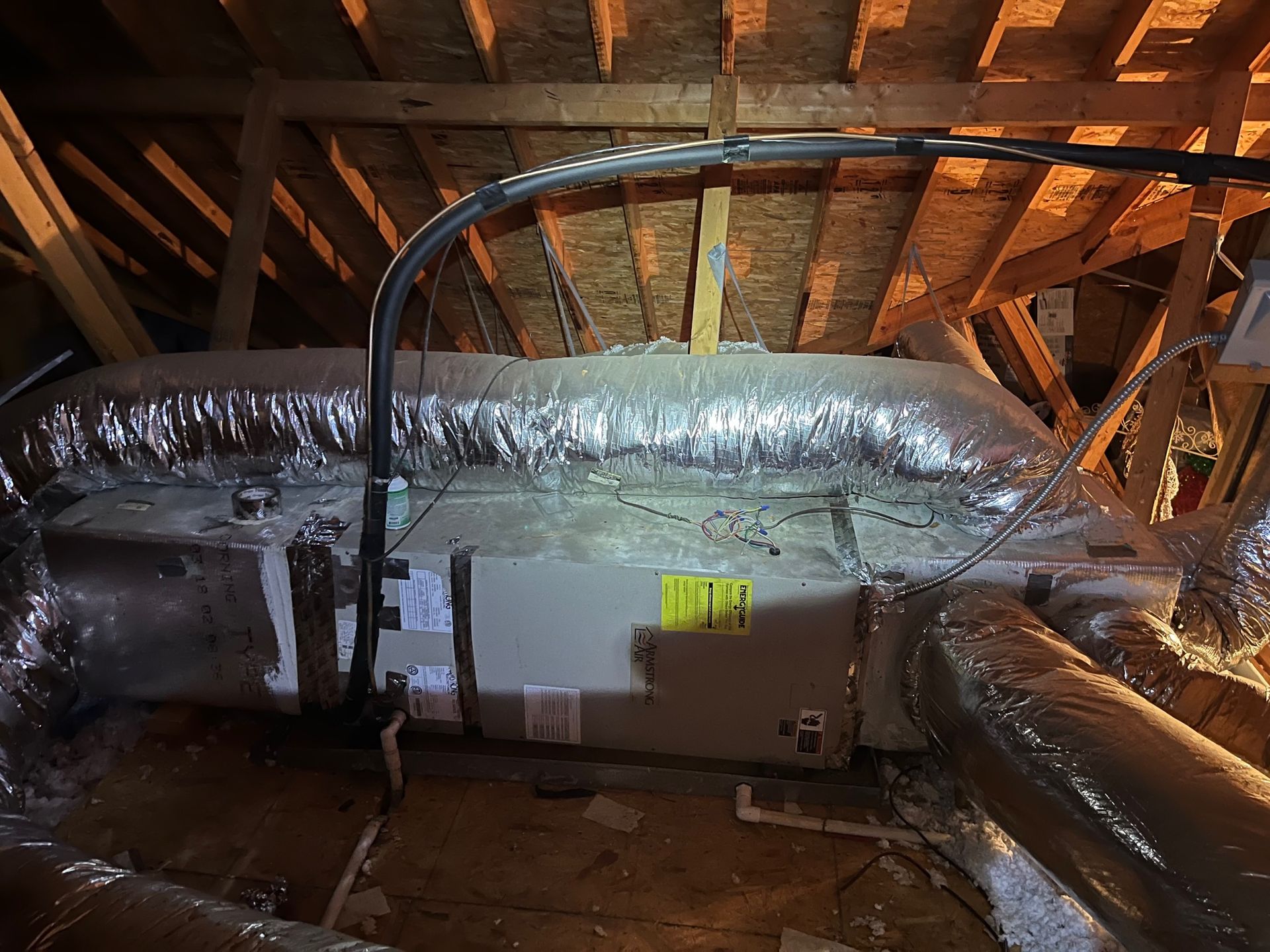A large air conditioner is sitting in the attic of a house.