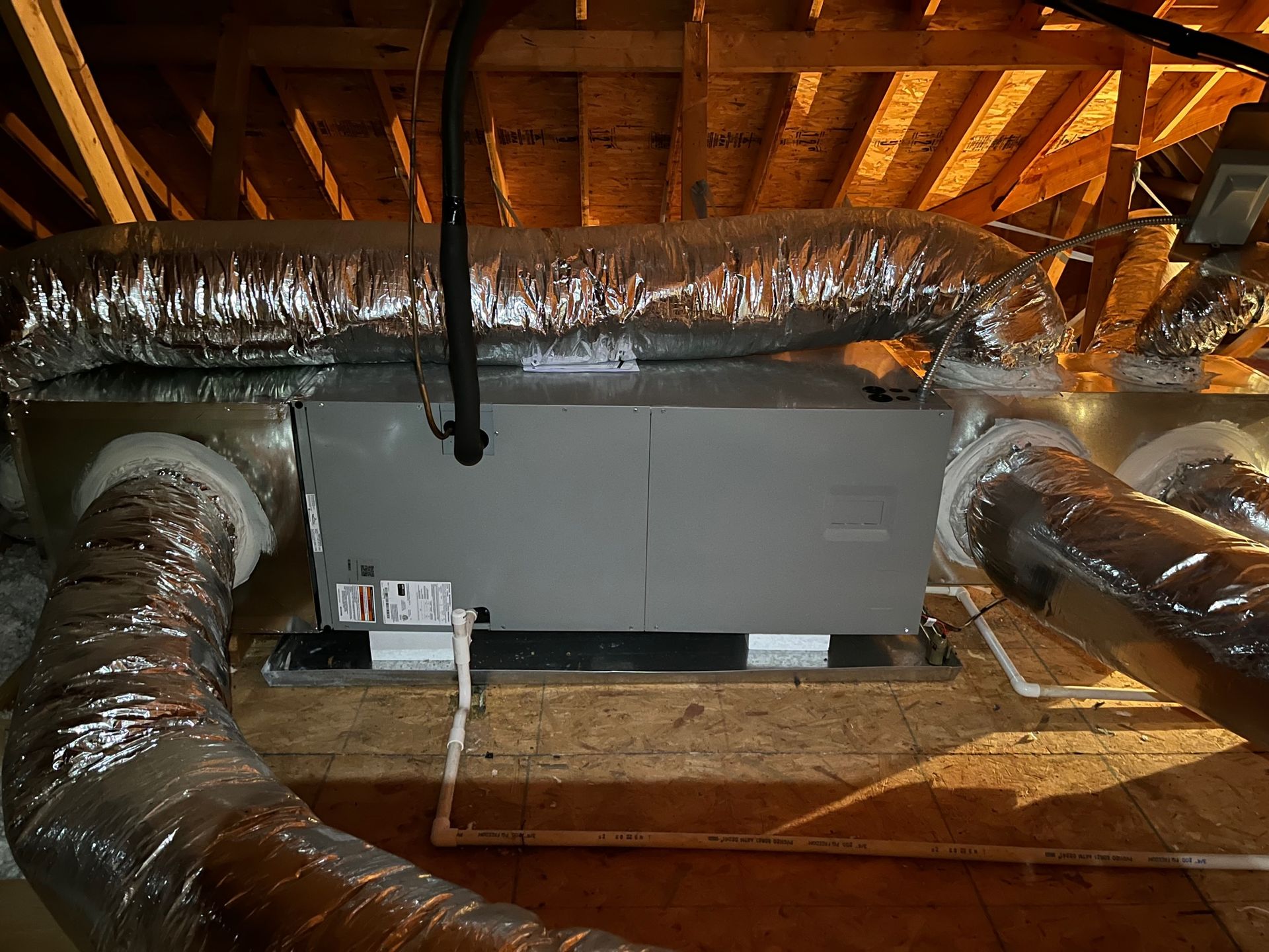 A ventilation system is installed in the attic of a house.