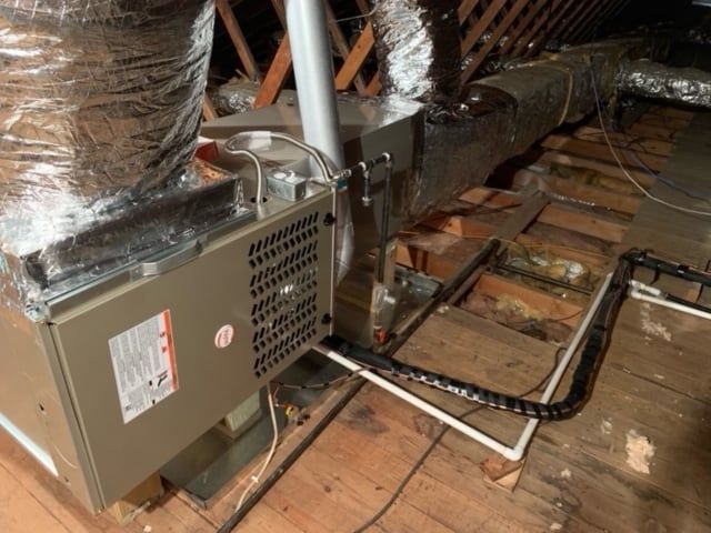 An air conditioner is sitting in the attic of a house.