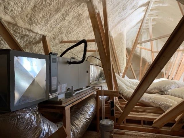 An attic with a lot of ducts and pipes