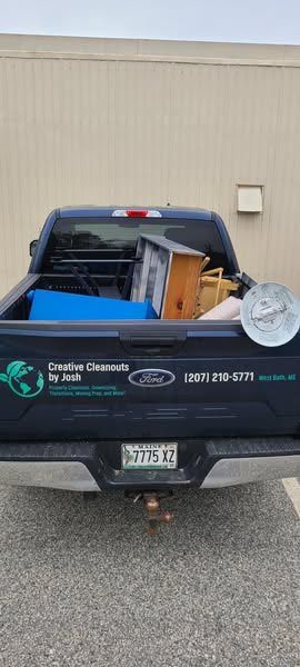 The back of a truck is filled with lots of junk.