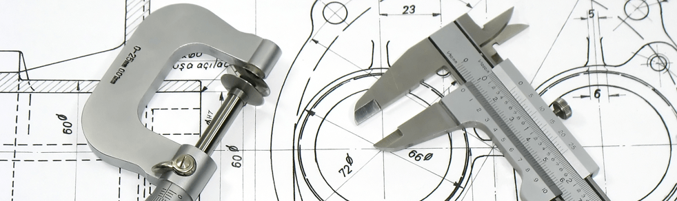 A pair of calipers are sitting on top of a drawing.