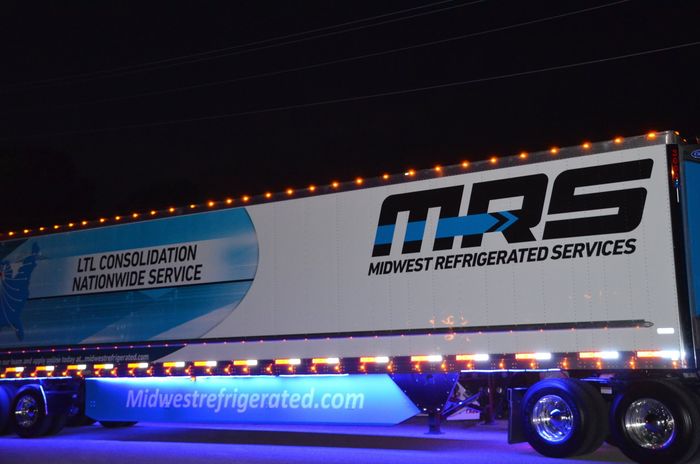 A mrs semi truck is parked on the side of the road at night