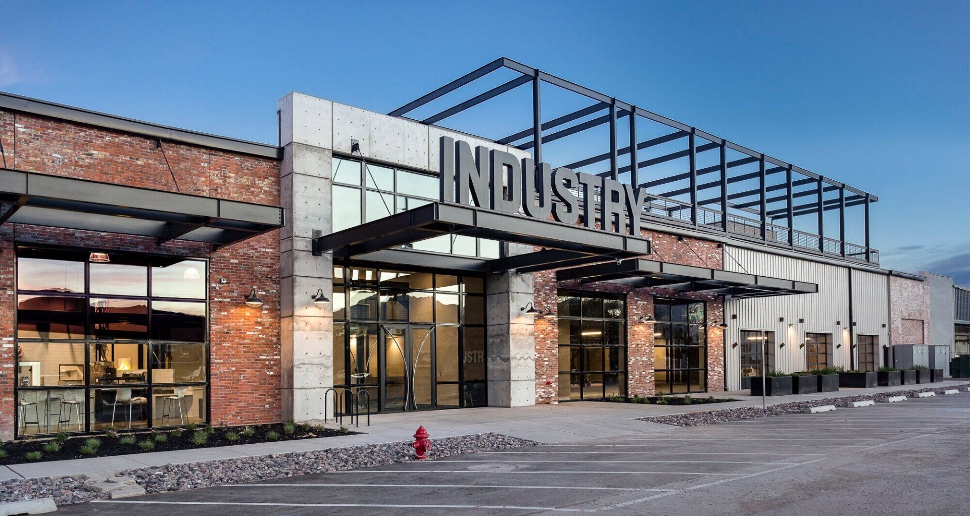 A large industrial building with a fire hydrant in front of it.