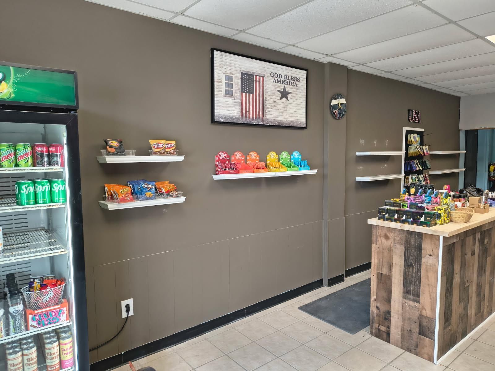 A store with a refrigerator , shelves , and a counter.