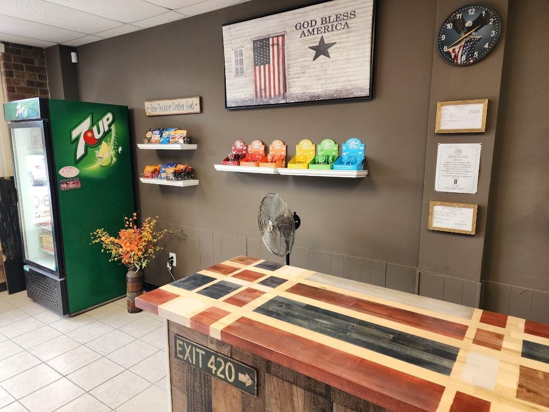 Reception area with a colorful, geometric counter, a 7up vending machine, and a patriotic American flag art piece.