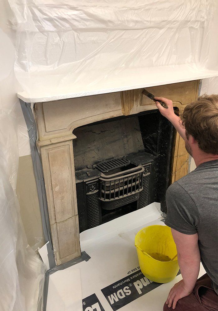 man reconditioning stone fireplace