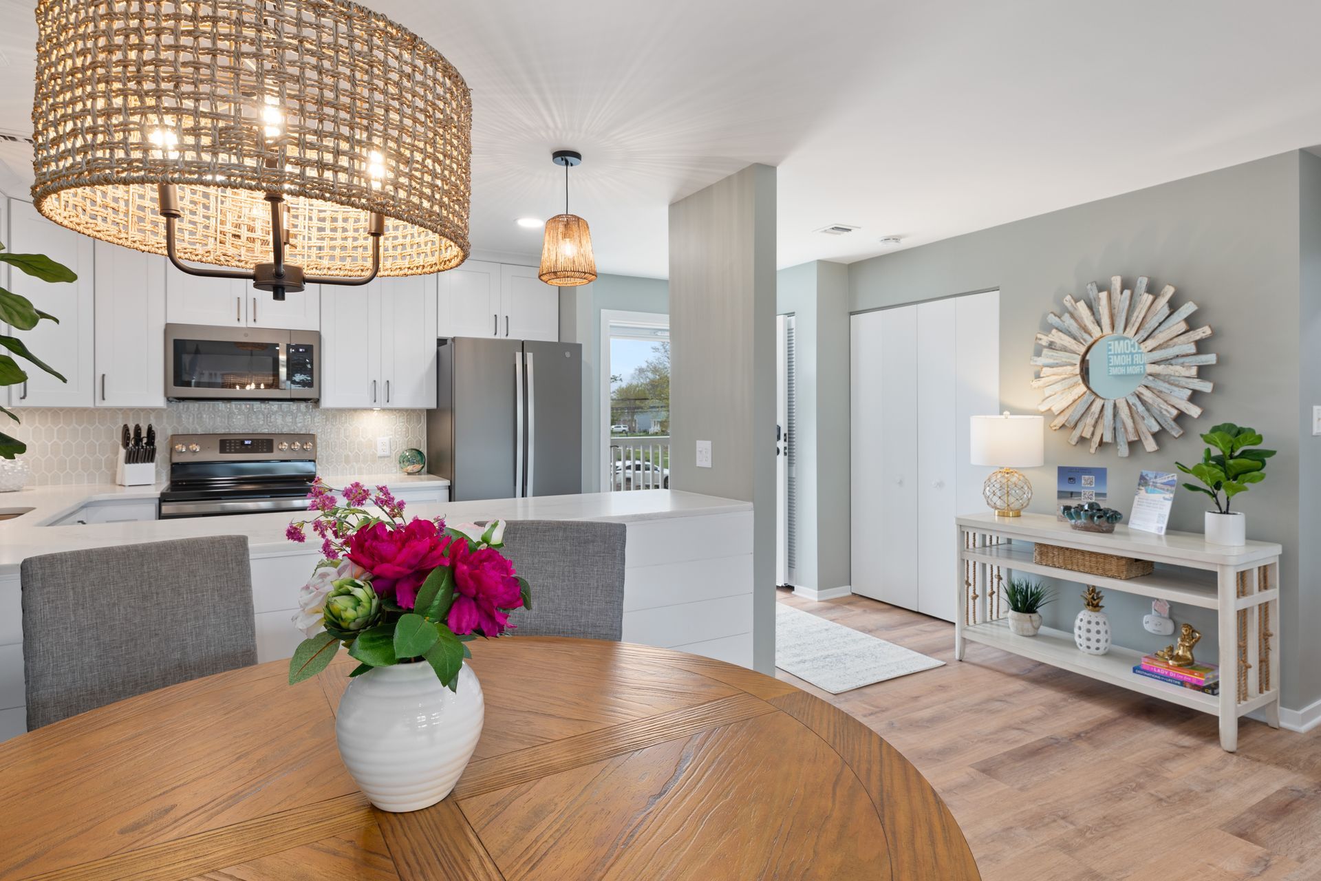 There is a vase of flowers on the table in the kitchen.