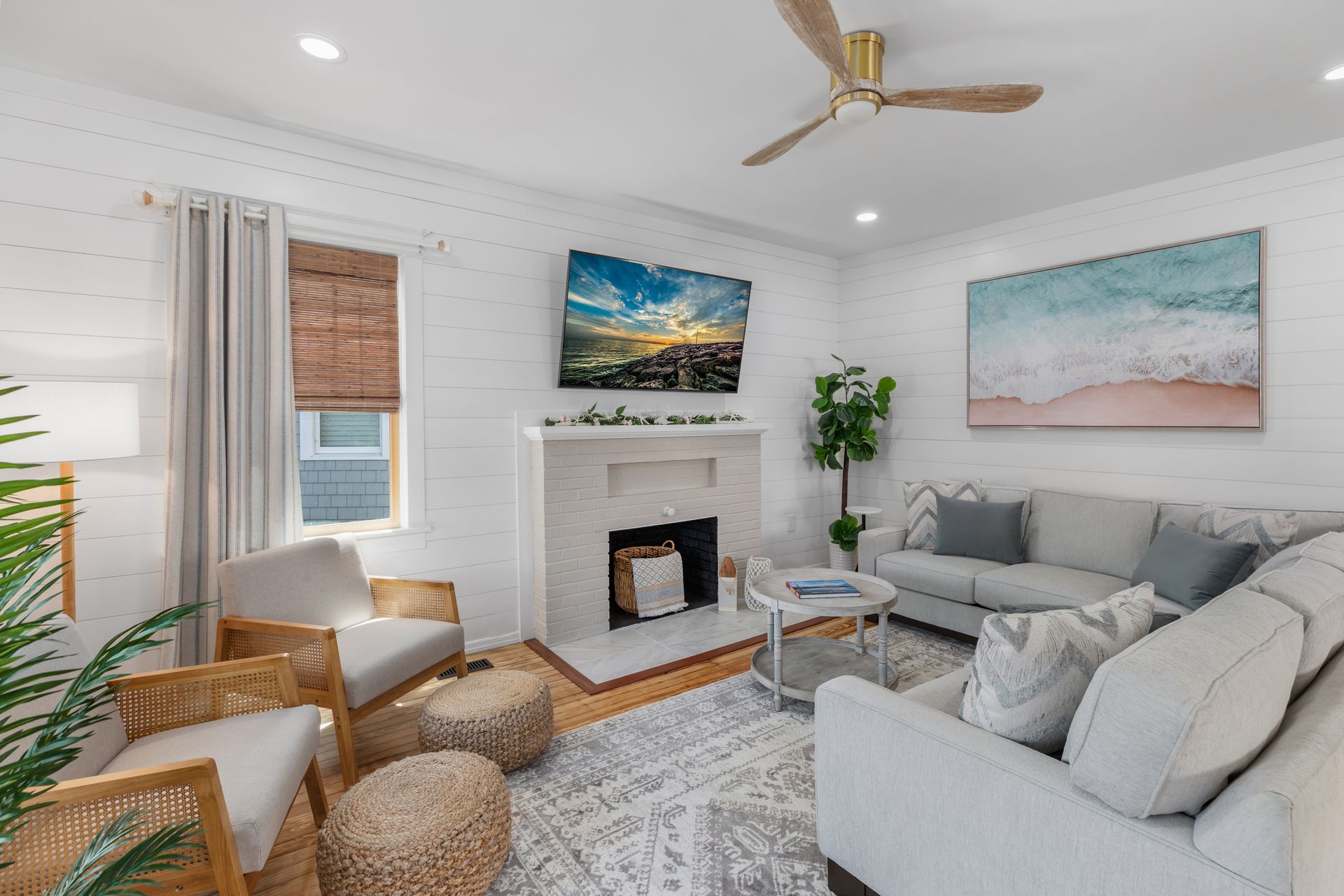 A living room with a couch , chairs , fireplace and television.