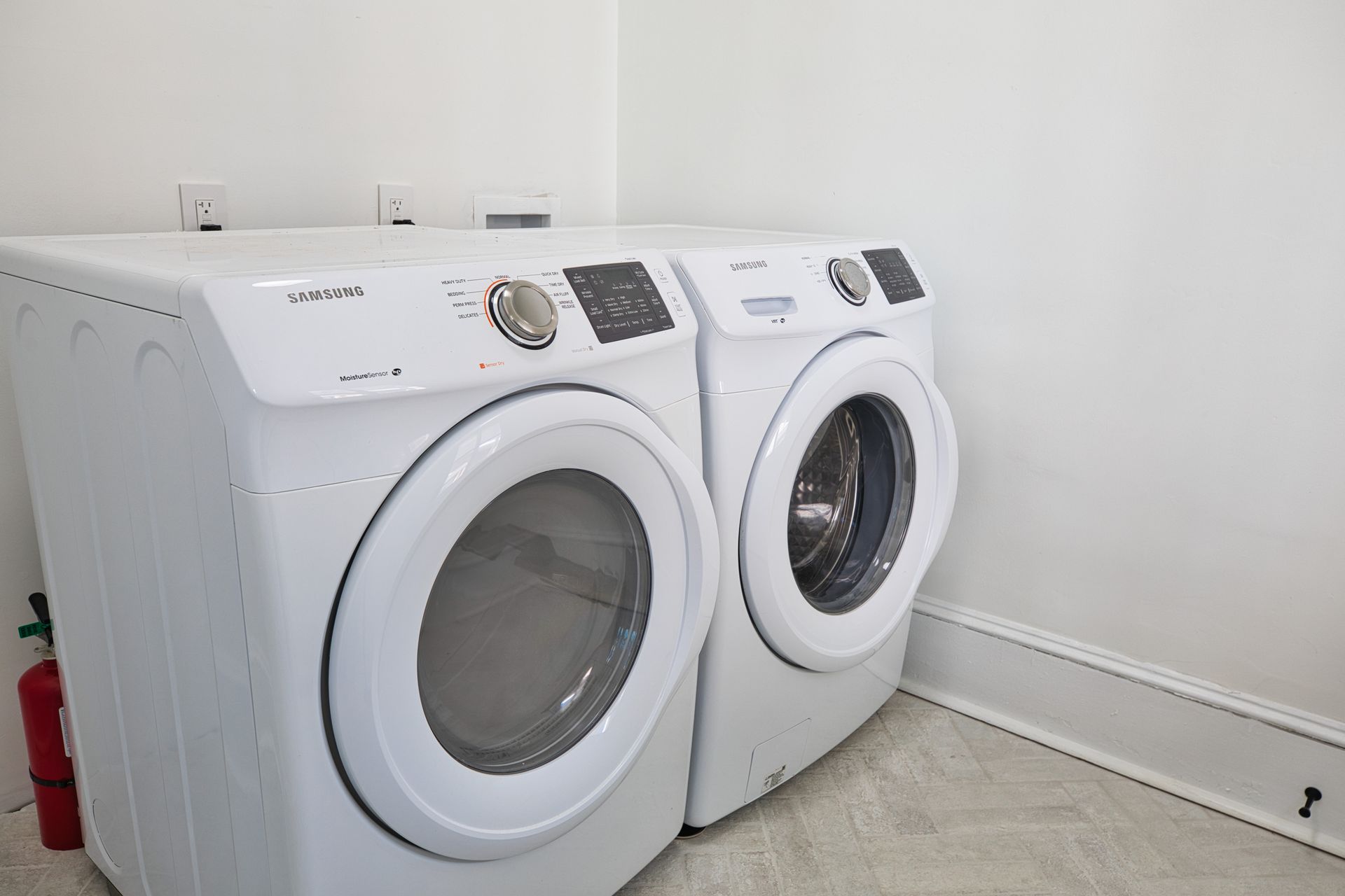 A washer and dryer are sitting next to each other in a laundry room.