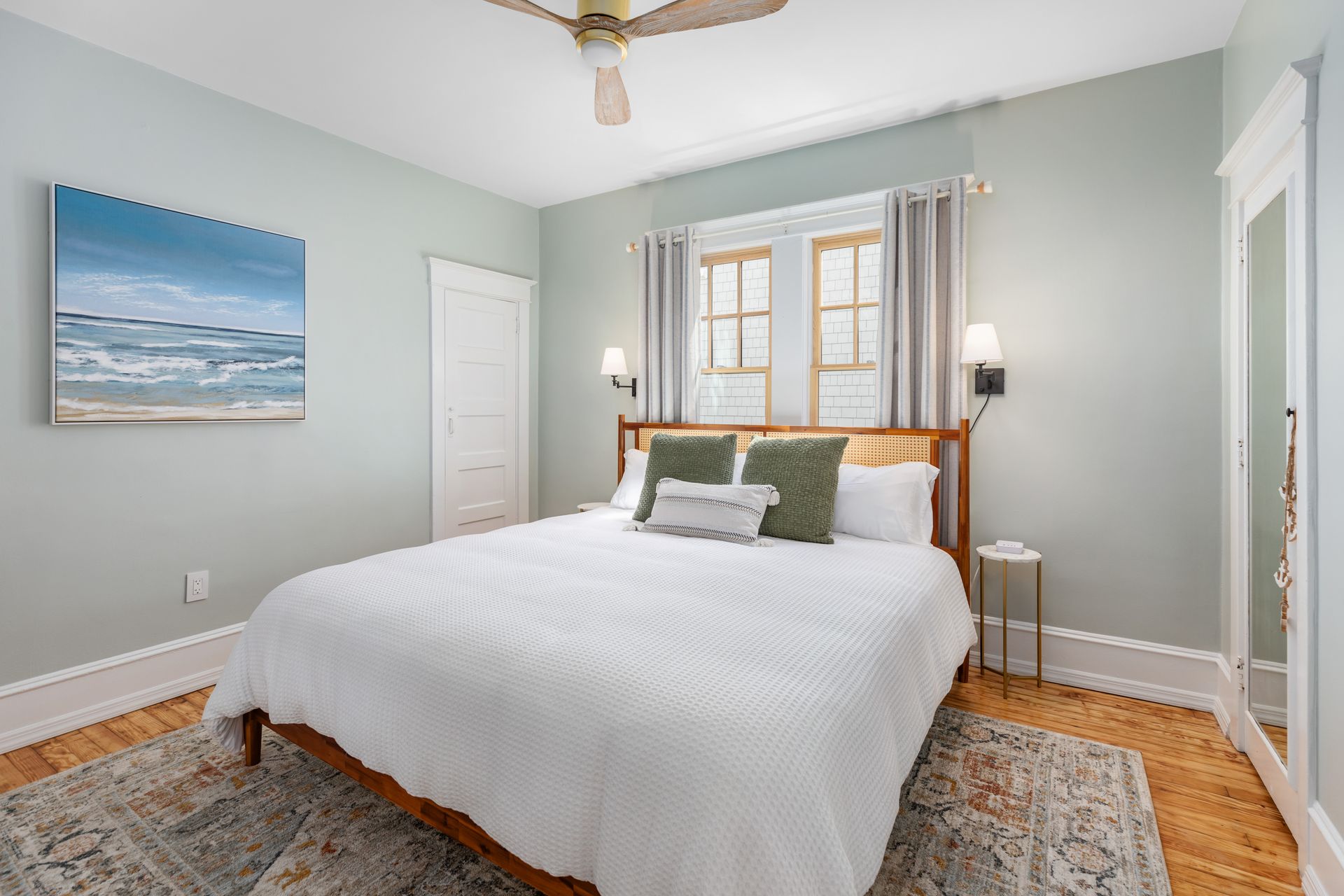 A bedroom with a king size bed and a ceiling fan.