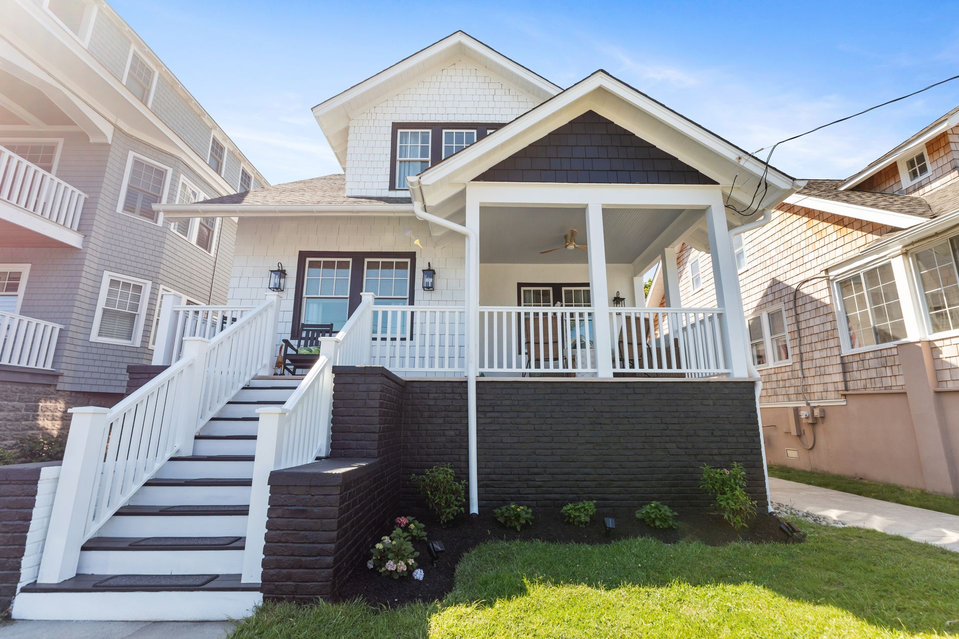 The front of a house with stairs leading up to the porch.