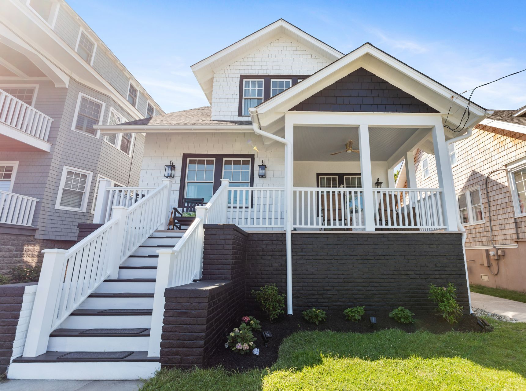 A black and white house with stairs leading up to the front porch.