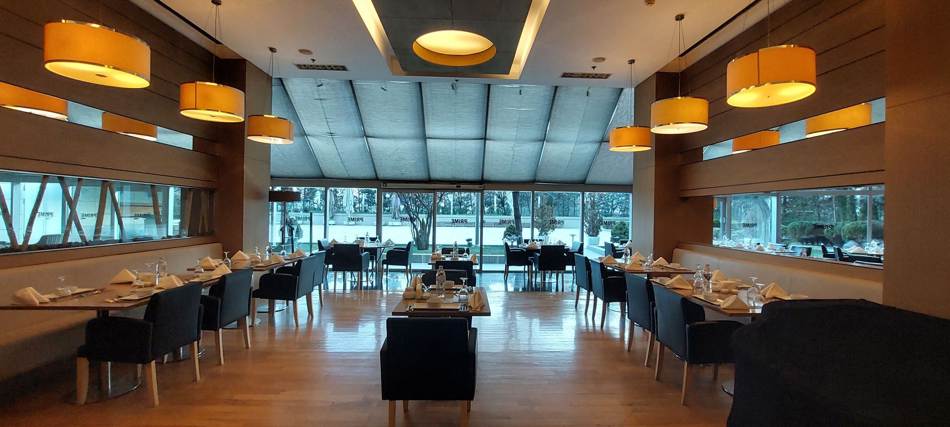 A restaurant with tables and chairs and a large window.