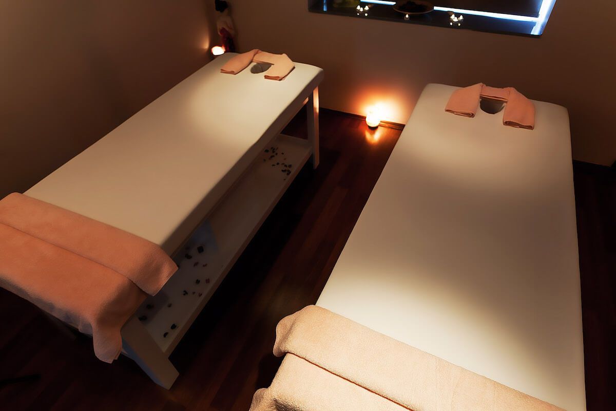 Two massage tables with pink towels on them in a room