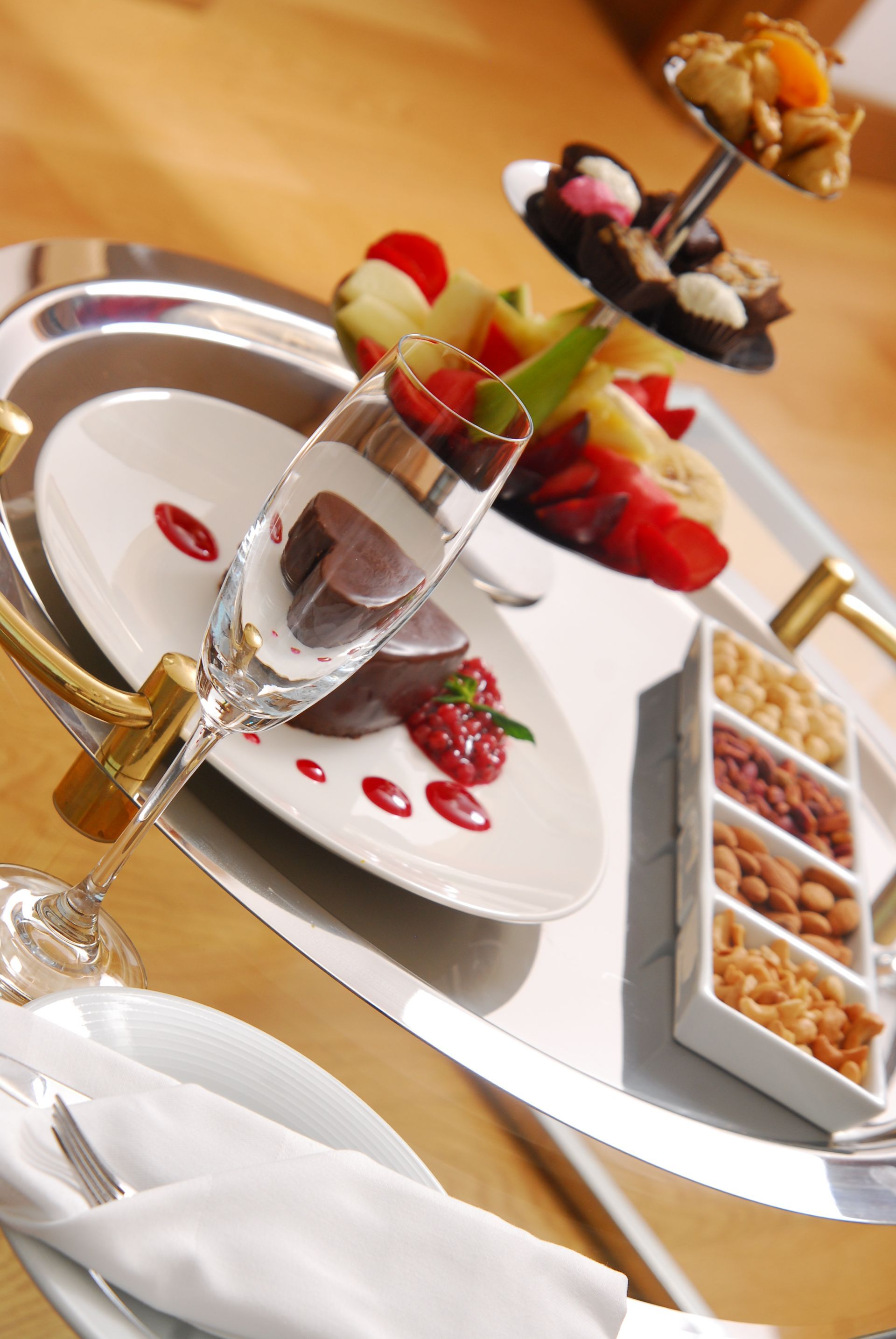 A silver tray with a plate of food and nuts on it