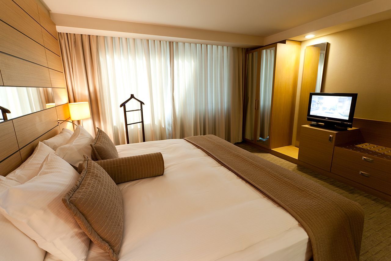 A hotel room with a large bed and a flat screen tv
