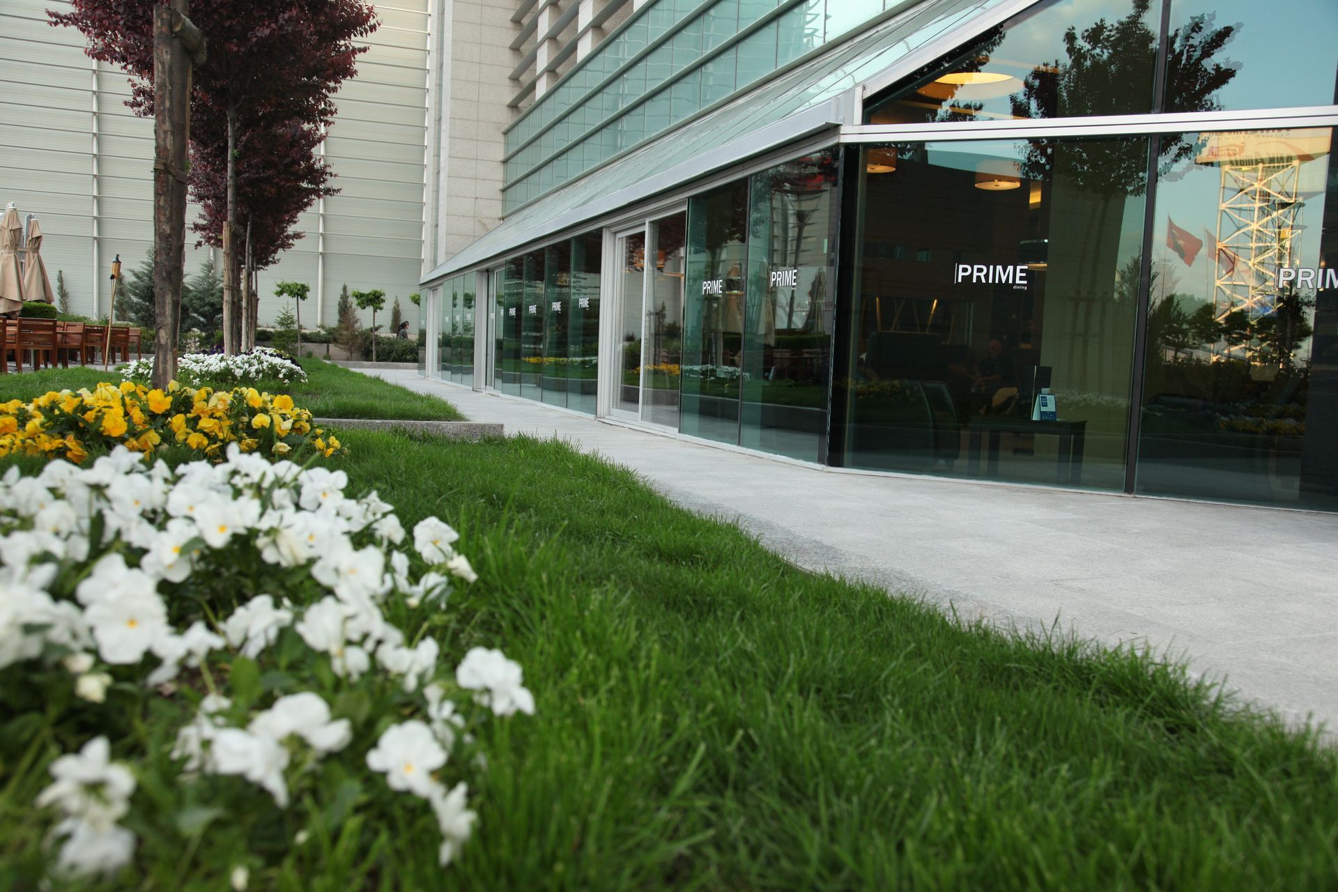 A building with a lot of windows and flowers in front of it