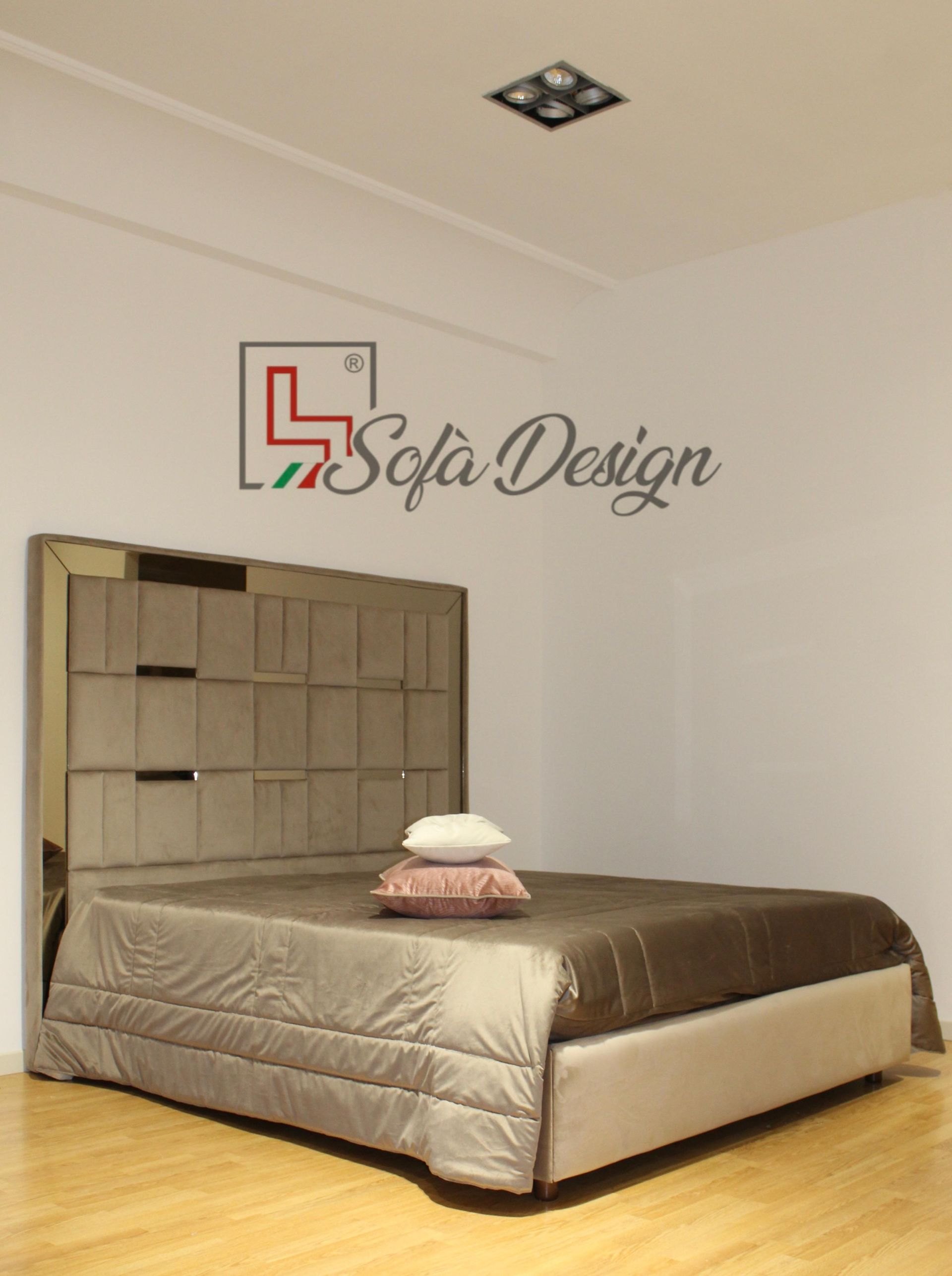 Letto moderno con testiera alta e fantasia e biancheria da letto marrone in una stanza bianca minimalista.