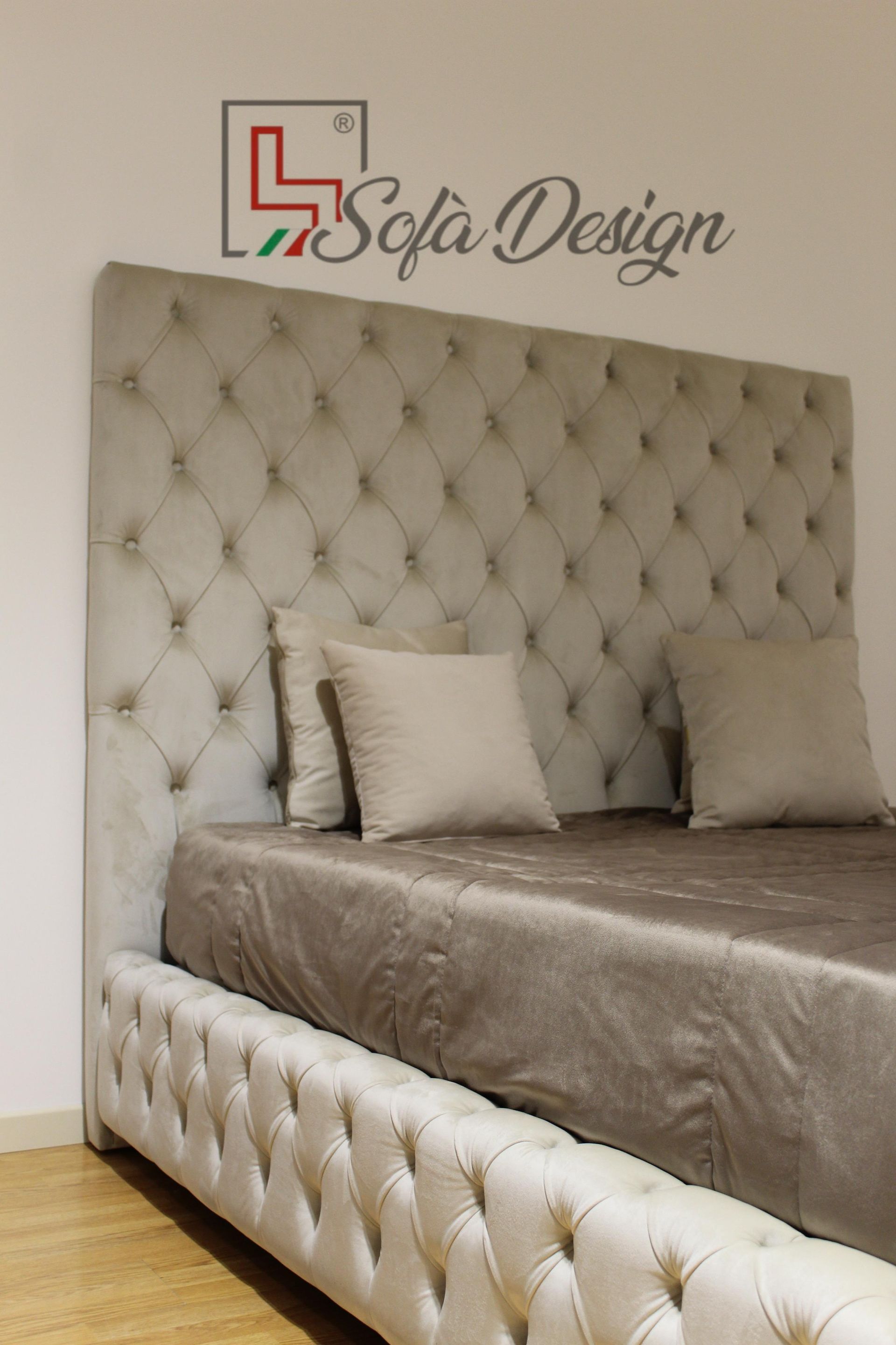 Letto capitonné con ampia testiera in un colore neutro chiaro e giroletto coordinato.