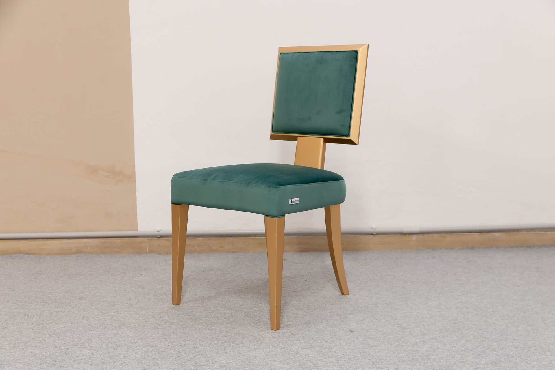 Sedia imbottita verde con struttura in legno su sfondo neutro.