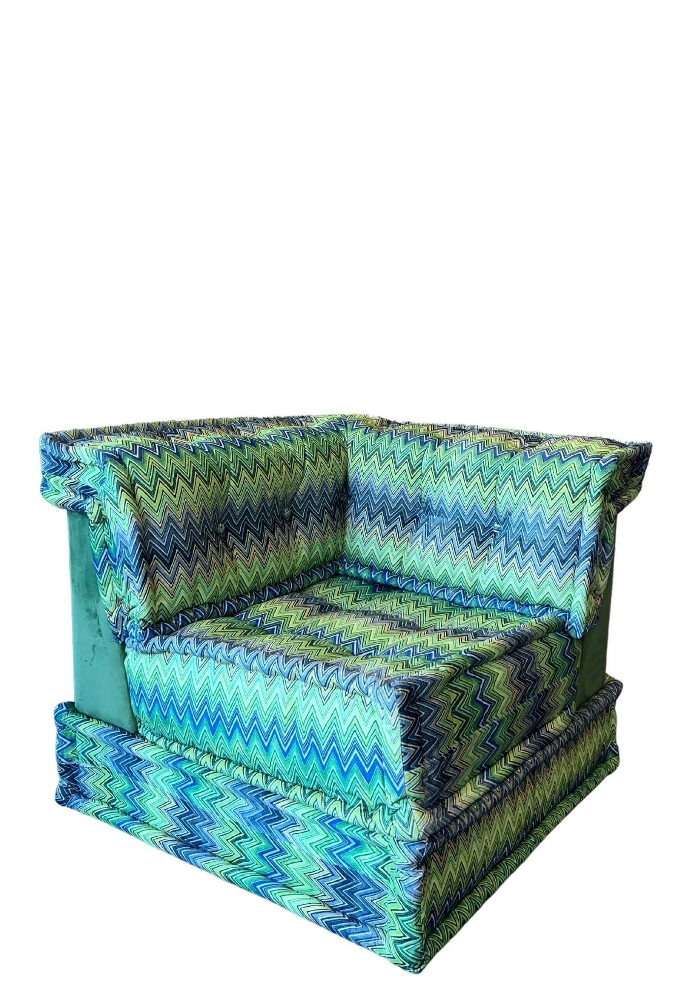 Un divano angolare con tessuto a maglia blu e verde su sfondo bianco.