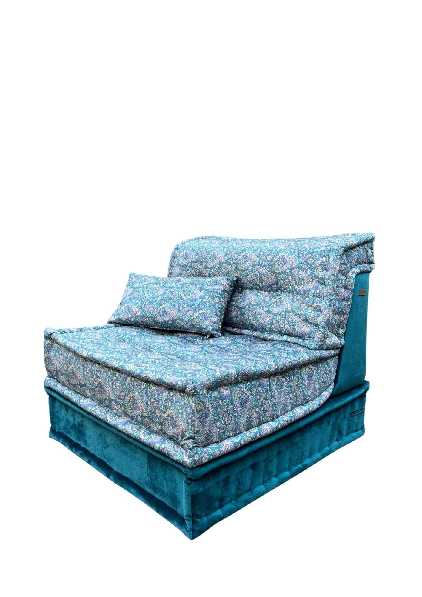 Sedia moderna imbottita con fantasia blu e verde acqua, dotata di due cuscini.