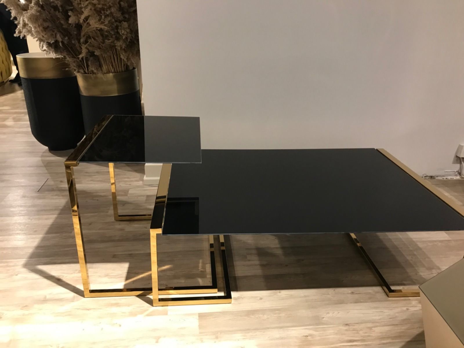 Elegante soggiorno con divano beige, tavolino in marmo, lampadari e pannelli decorativi alle pareti.