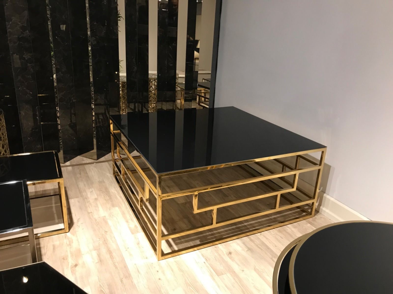 Tavolino da caffè quadrato nero e oro in un soggiorno moderno.