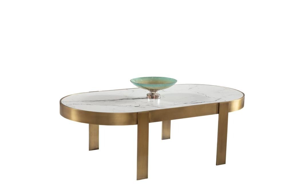 Tavolino ovale con gambe in ottone, piano bianco e ciotola verde.