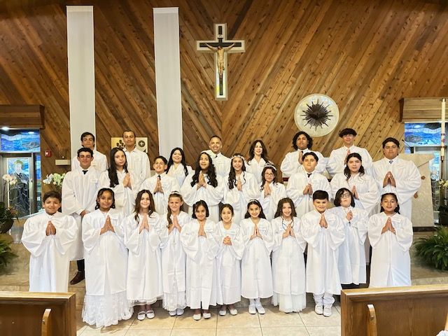 A group of people standing in front of a wooden cross