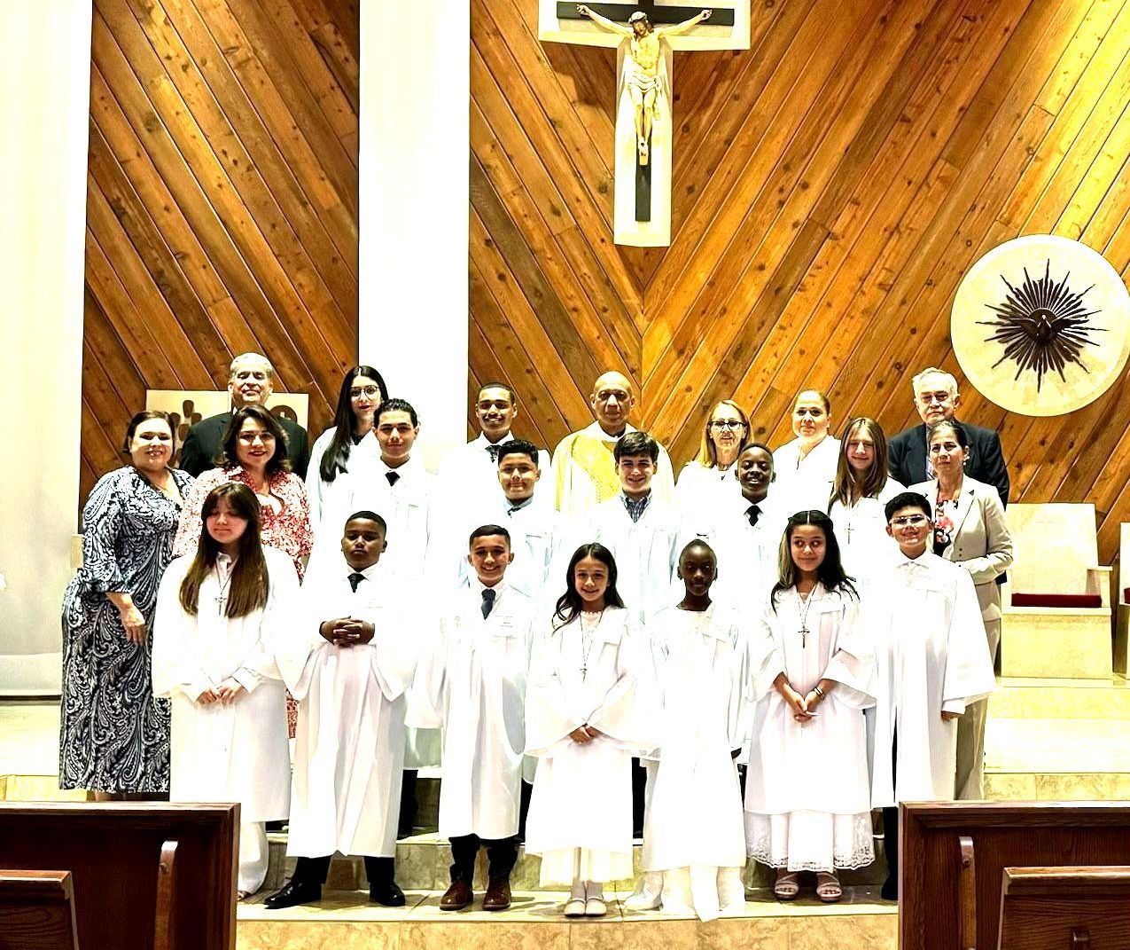 A group of people standing in front of a wooden cross