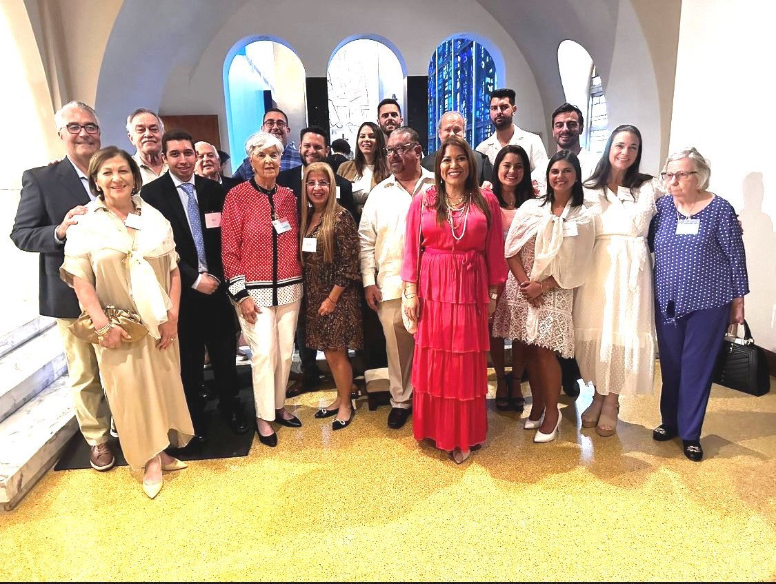 A group of people posing for a picture with one woman in a red dress