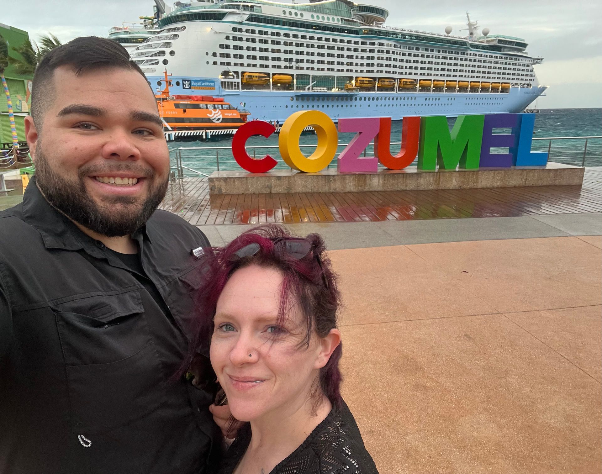 Couple smiling in front of a colorful