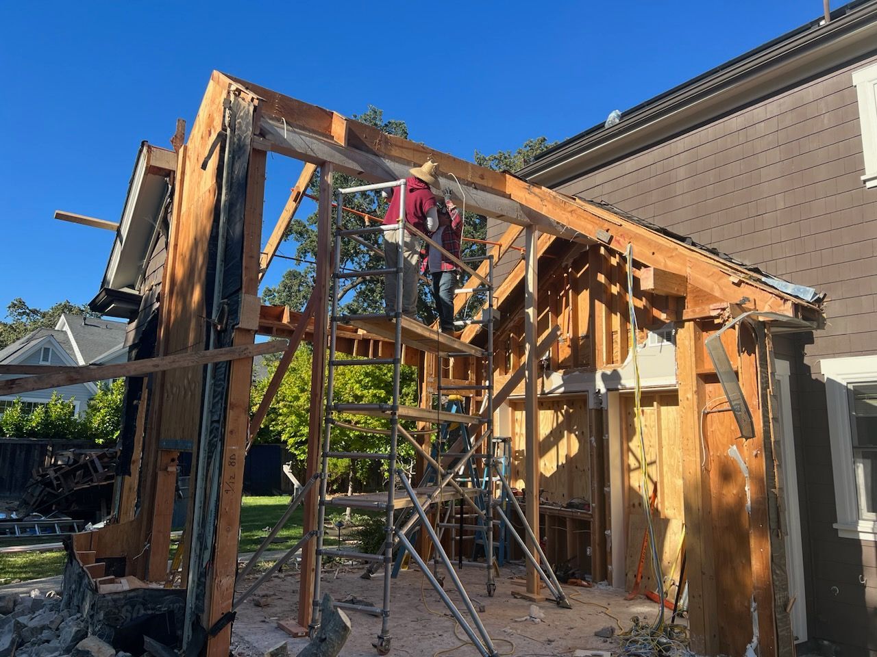 A man is standing on a scaffolding next to a building under construction.