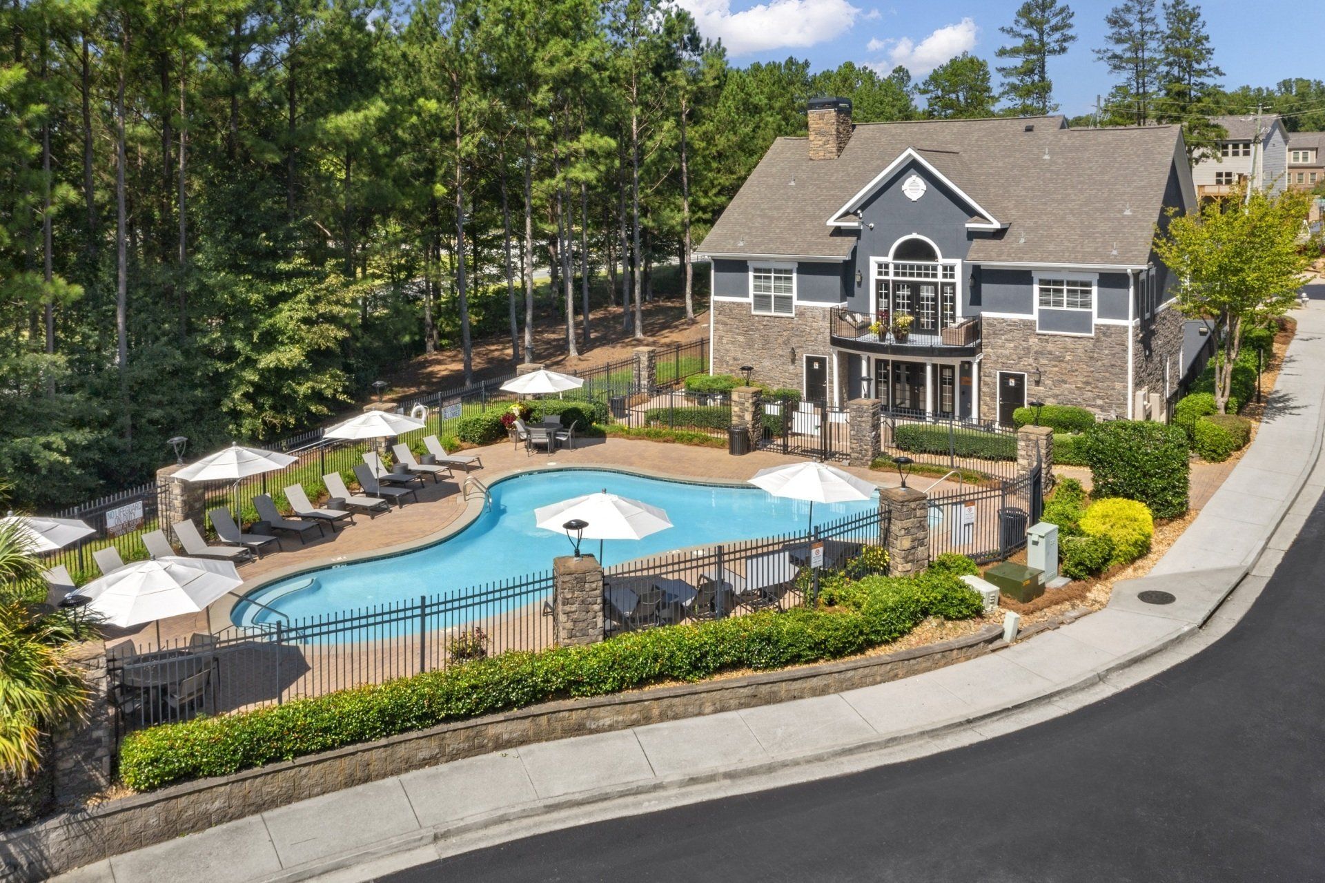 An aerial view of a house with a large pool in front of it