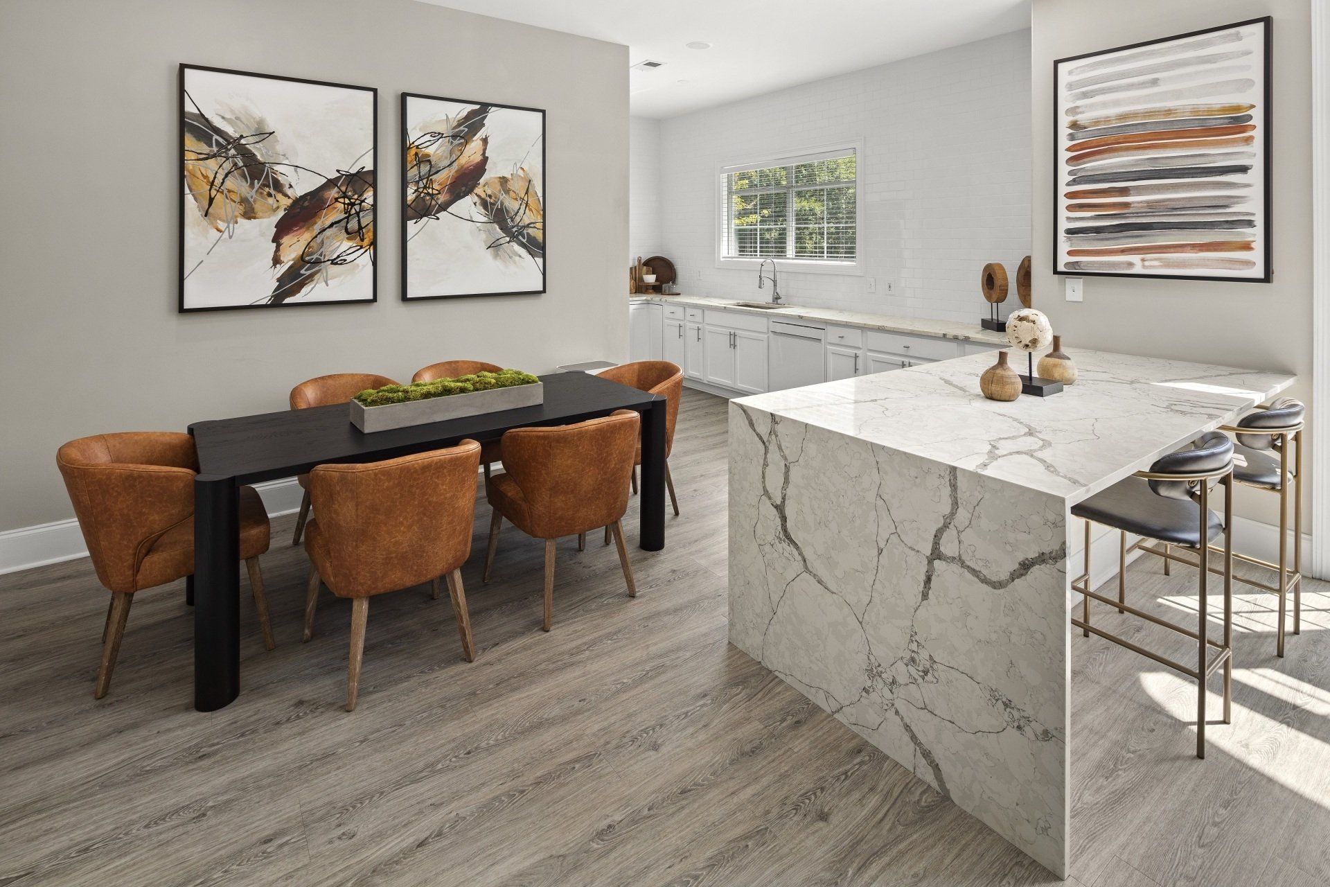 A dining room with a table and chairs and a kitchen.