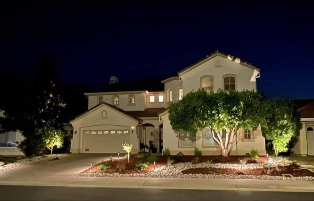 Frontyard remodel with no grass. The landscaping has beautiful plants, boulders and landscape lighting with a dry cobble stream.