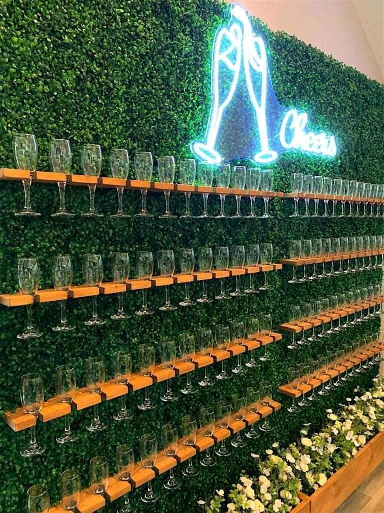 Green wall with champagne glasses on wooden shelves, 