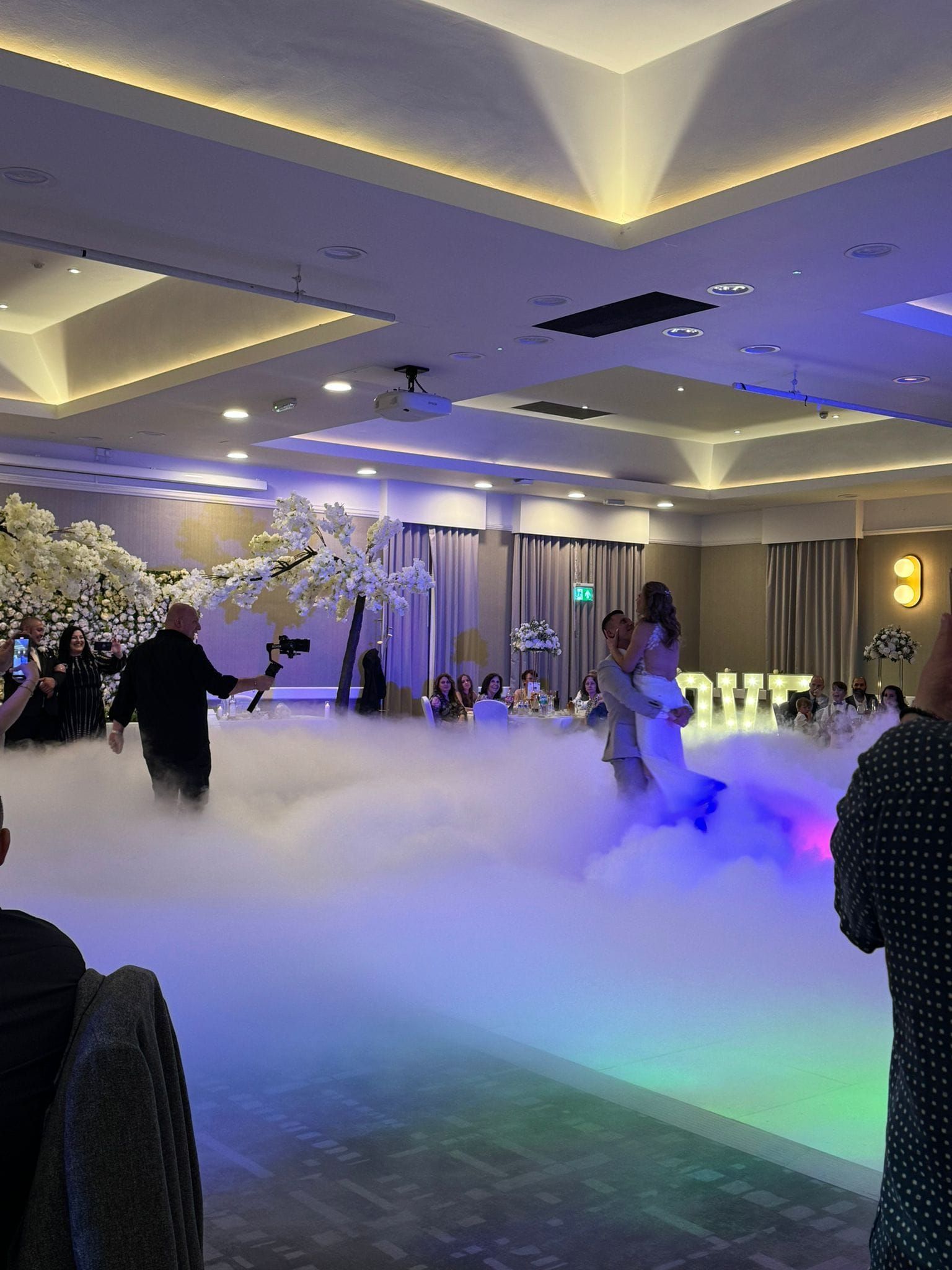Bride and groom dancing on a foggy dance floor at a wedding reception.