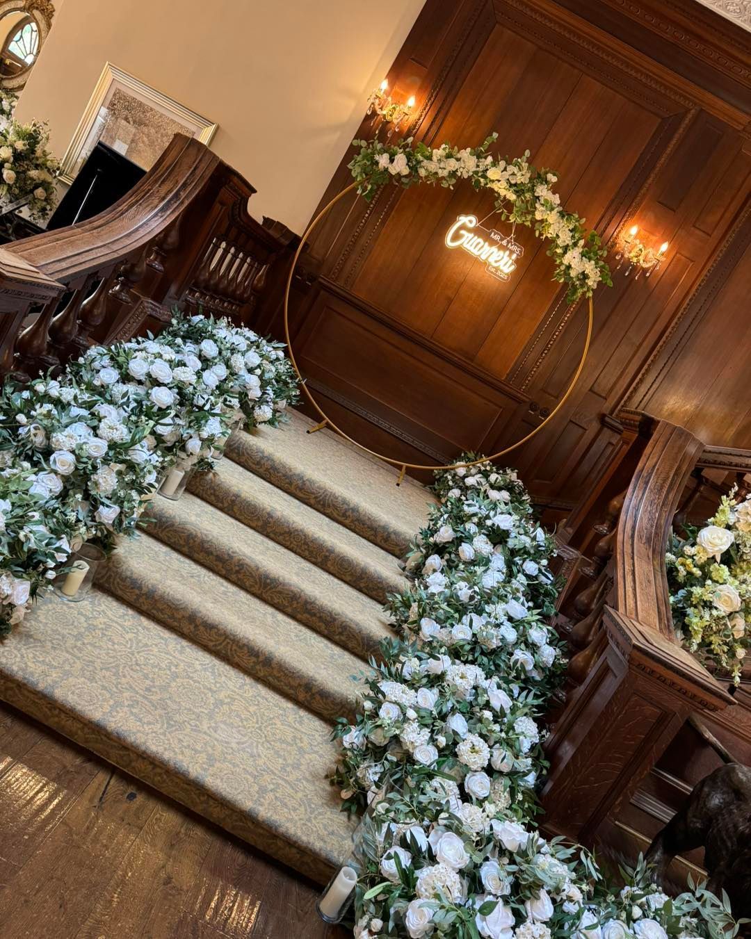 Staircase decorated with white flowers and gold hoop with 