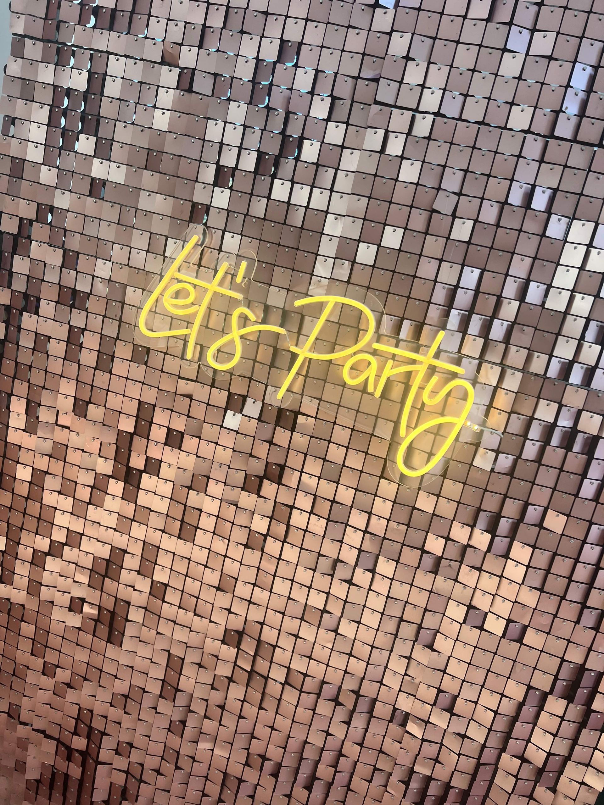Gold sequin wall with a neon 