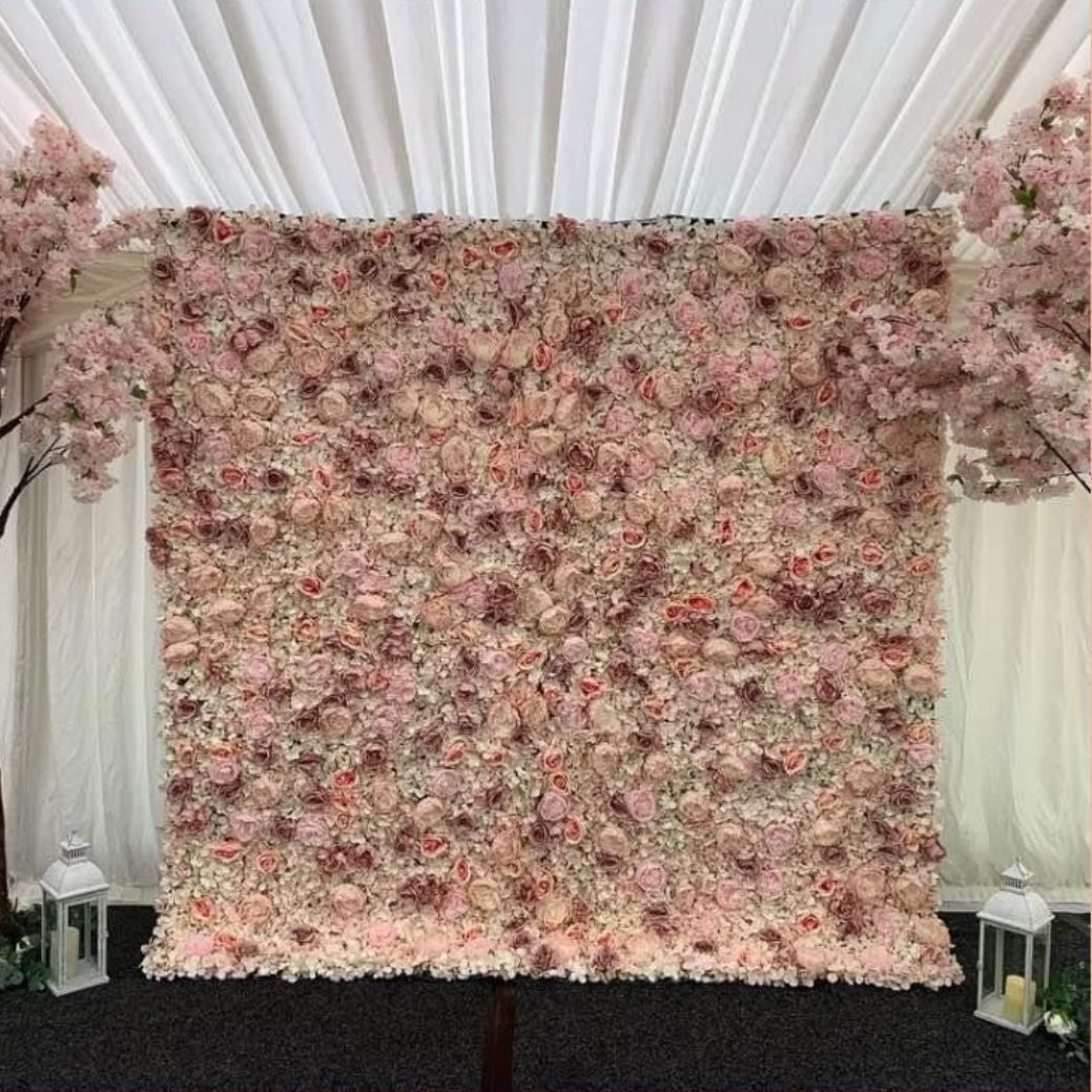 Pink floral backdrop with cherry blossom trees, white draping, and lanterns.