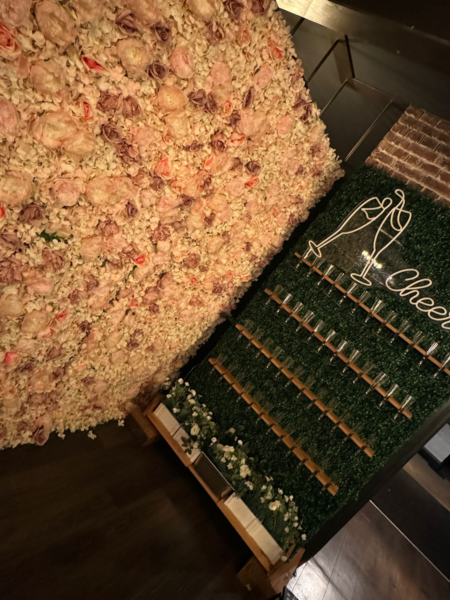 Floral and greenery wall with champagne flutes and 