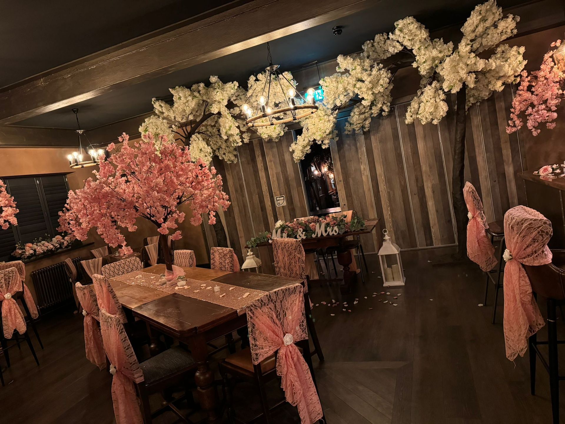 A decorated dining room with pink and white floral arrangements.