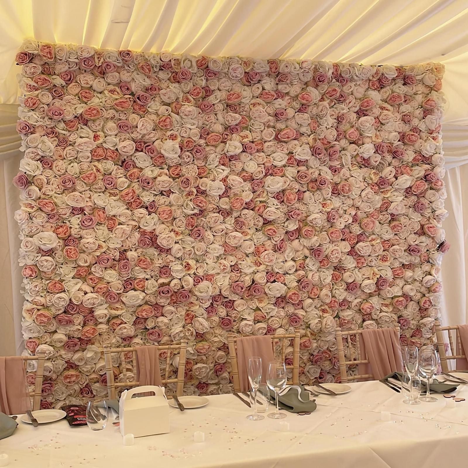 Flower wall backdrop with dining table set for a celebration; pink, white and gold.