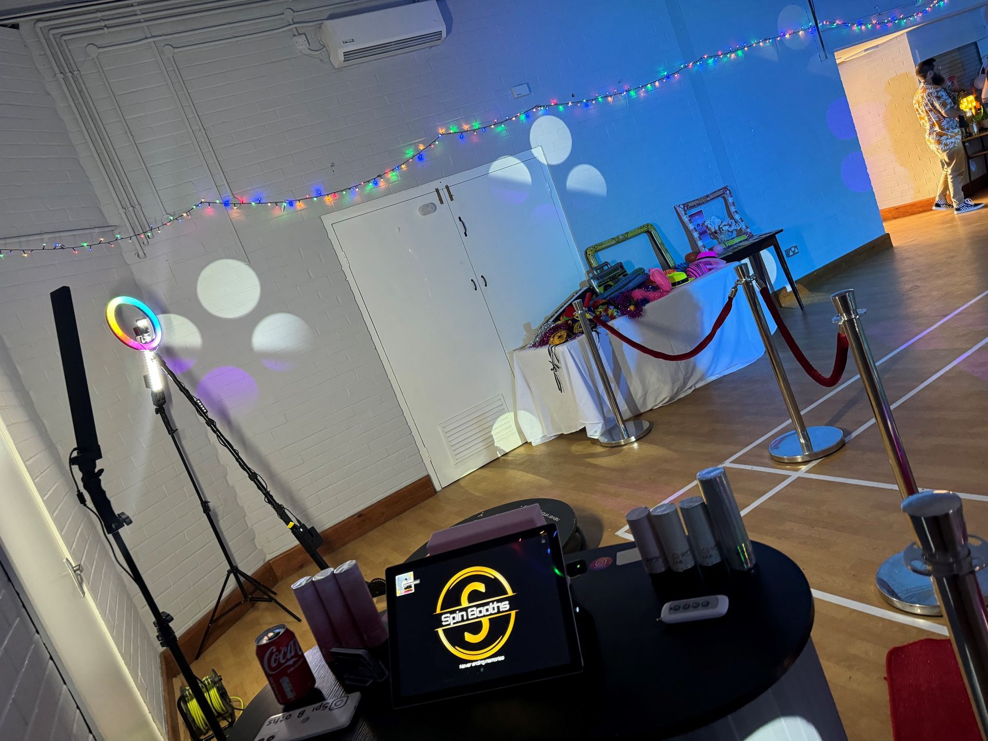 Photo booth setup with lighting, props, and a red velvet rope barrier.